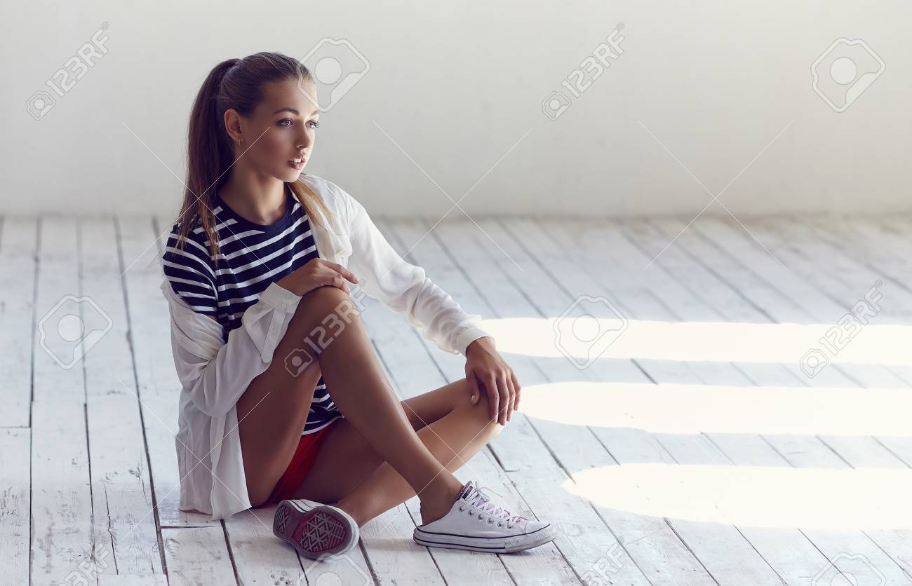 Slim Girls In Black And White Shirt Sitting On White Wooden Floor Stock Photo Slim Girls In Black And White Shirt Sitting On White Wooden Floor Stock Photo