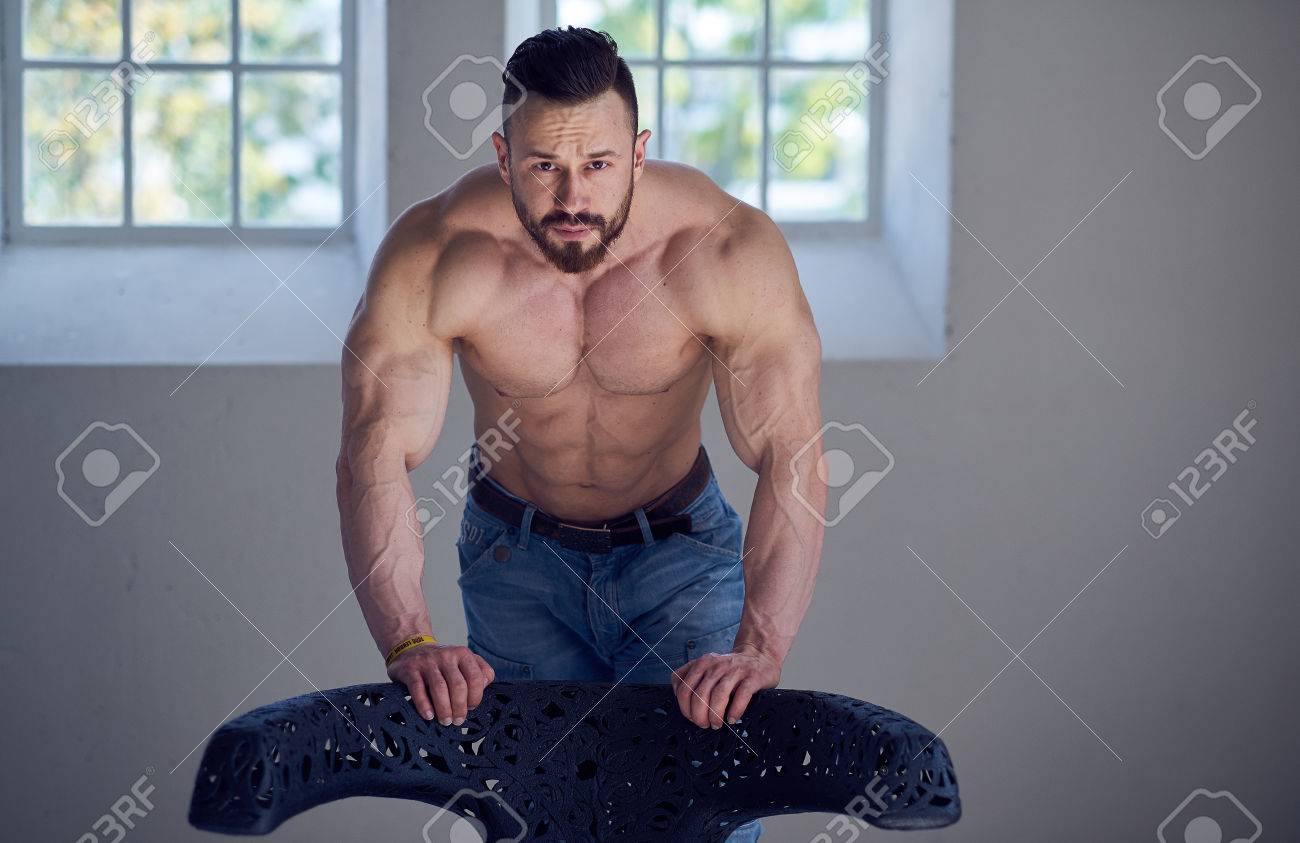 窓の近くのジーンズで上半身裸のボディービルダーの男性モデルの肖像画