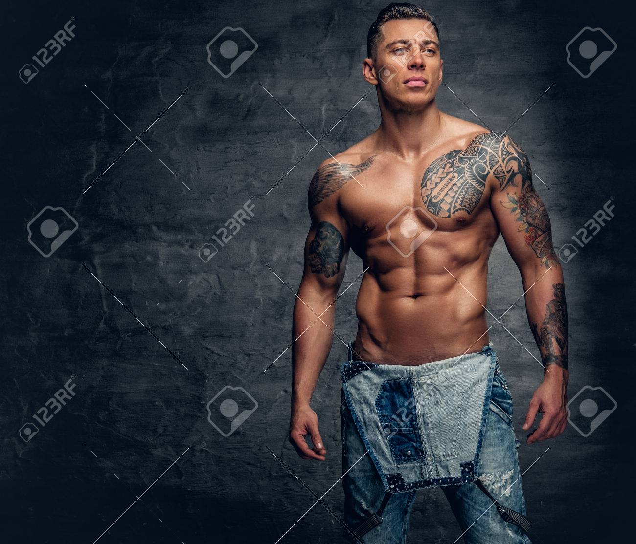 Studio Portrait Of Handsome Muscular Male Fitness Model With Tattoo On A  Chest Dressed In A Jeans. Stock Photo, Picture And Royalty Free Image.  Image 74814079.