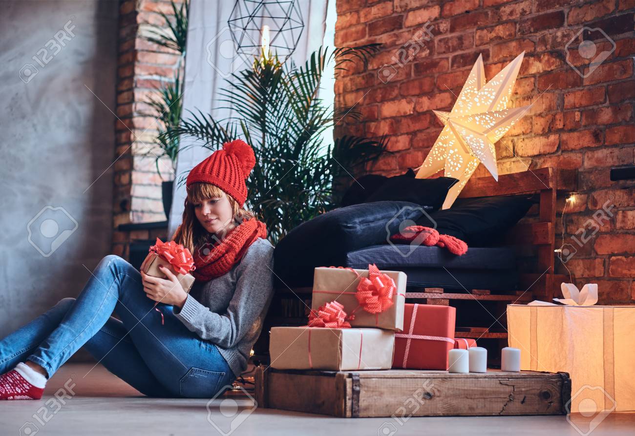 女性はロフト付きのリビングルームでクリスマスプレゼントを Interi の写真素材 画像素材 Image