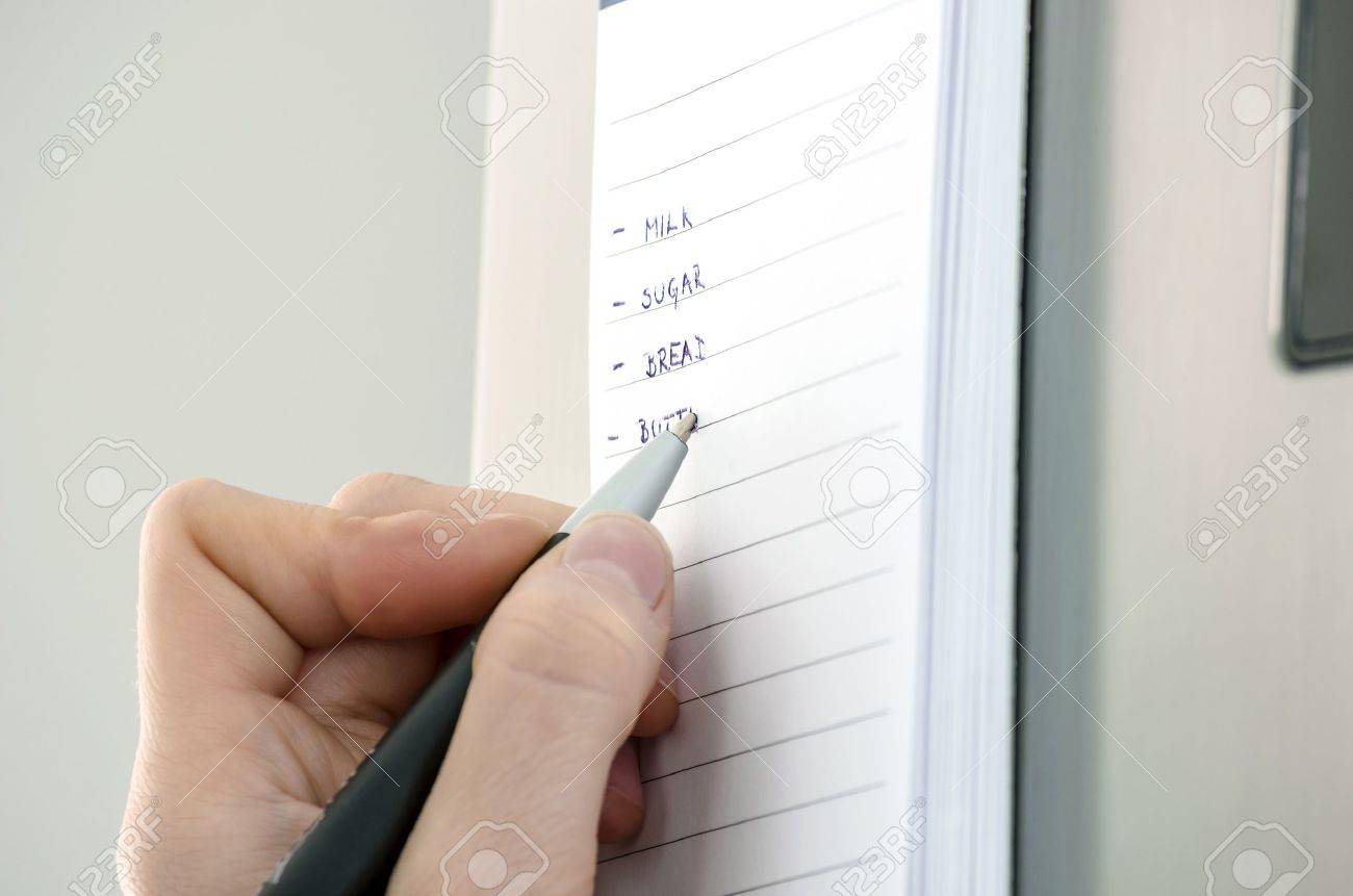 Kühlschrank Einkaufsliste Magnet : Female hand writing einkaufsliste auf einer klebrigen notiz am Kühlschrank Einkaufsliste Magnet : Female hand writing einkaufsliste auf einer klebrigen notiz am