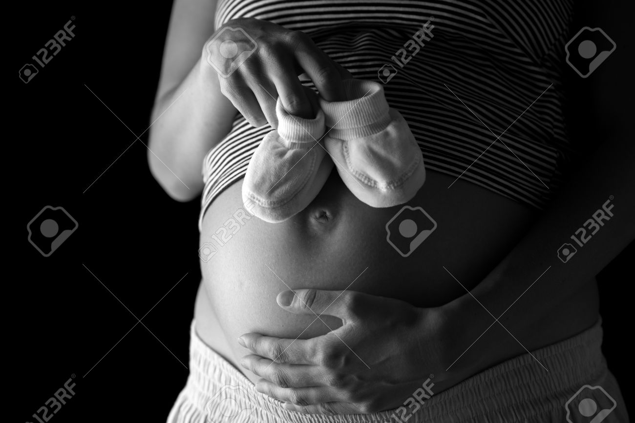 Femme Enceinte Tenant Une Paire De Chaussons De Bebe Mignon Dessus De Son Abdomen Gonfle Banque D Images Et Photos Libres De Droits Image