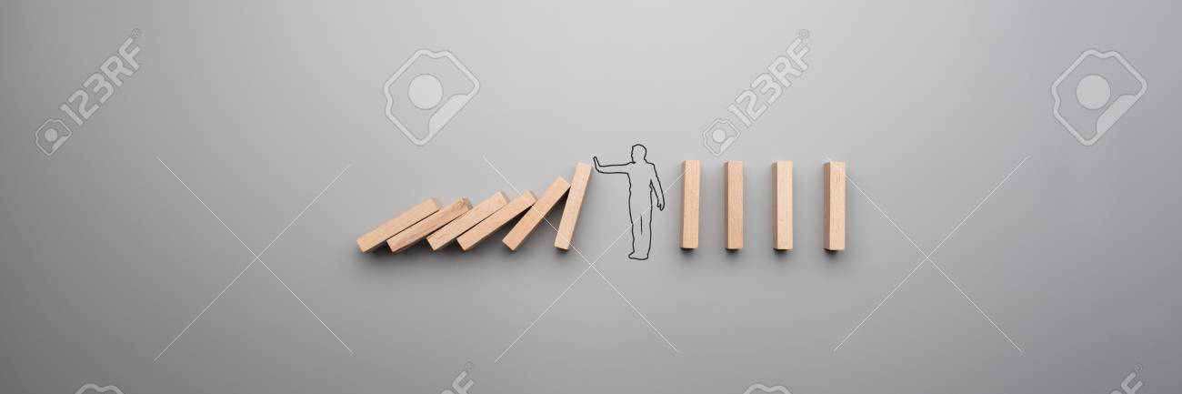 Wide cropped image of the outline of a businessman stopping the domino effect on gray background. - 104601082 Wide cropped image of the outline of a businessman stopping the domino effect on gray background. - 104601082