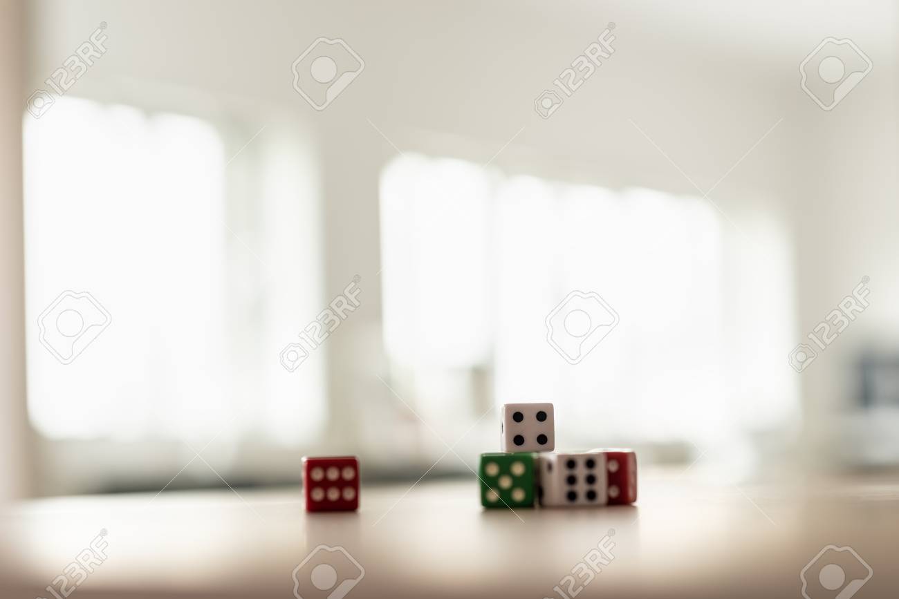 Gaming dice stacked on desk in a bright office. - 109027095 Gaming dice stacked on desk in a bright office. - 109027095