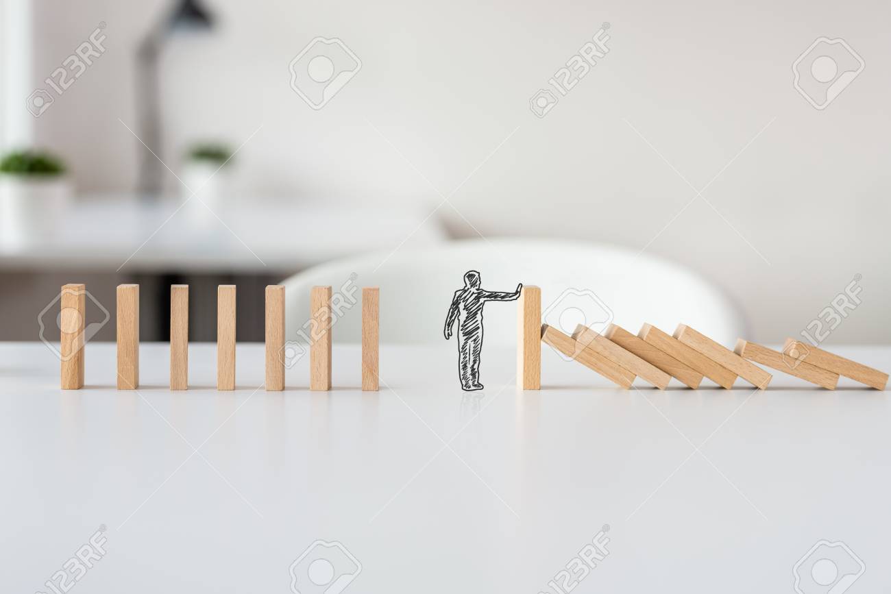 Hand drawn shape of businessman stopping domino effect in a conceptual image of solving business crisis. - 113035031 Hand drawn shape of businessman stopping domino effect in a conceptual image of solving business crisis. - 113035031
