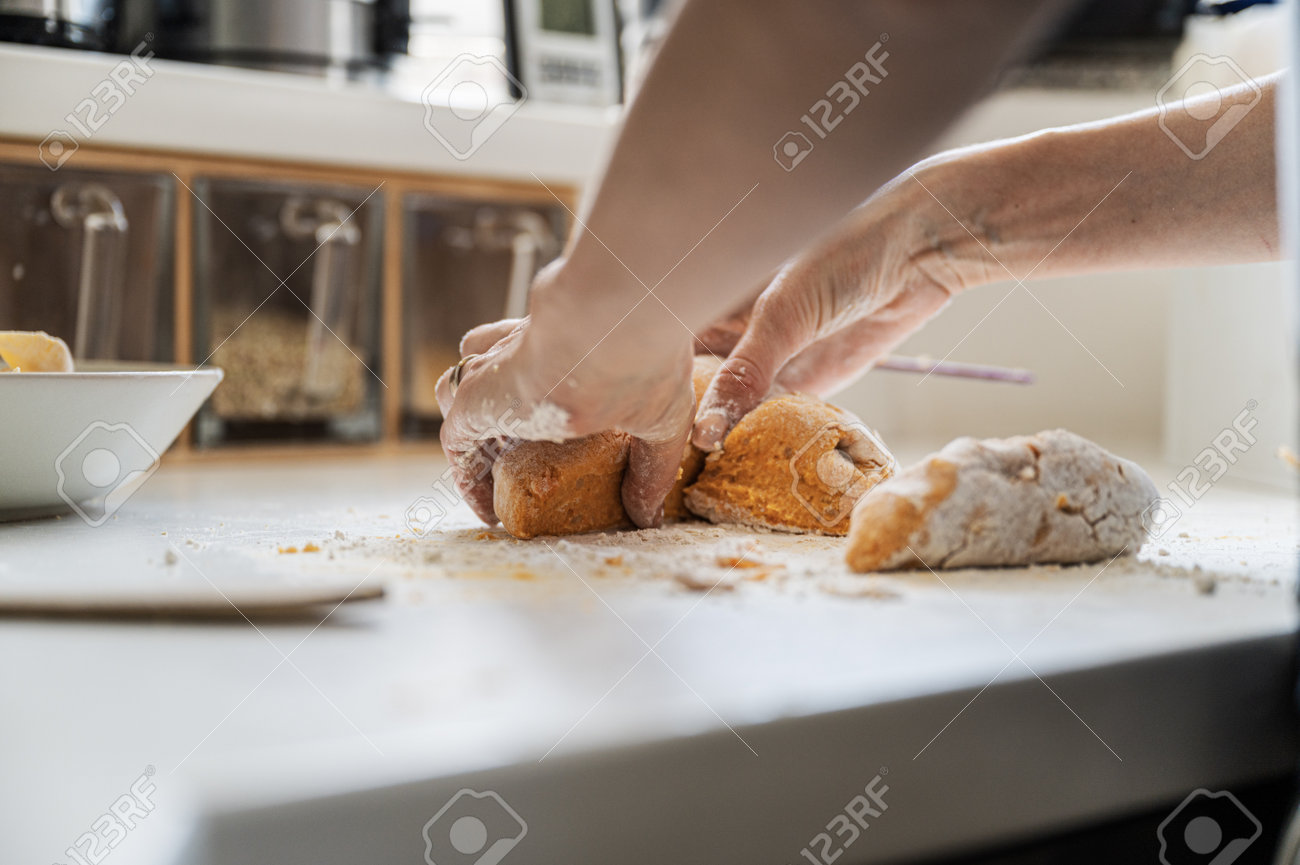 Low angle view of a woman preparing a dough for home made pasta on kitchen counter. - 169239390 Low angle view of a woman preparing a dough for home made pasta on kitchen counter. - 169239390