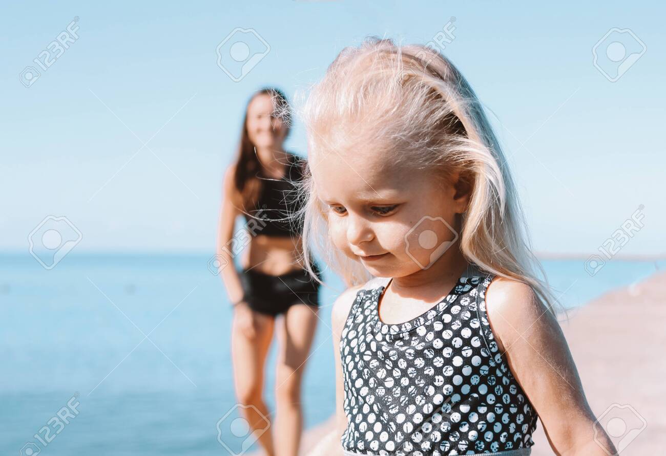 Little cute girl running to fit mom on the beach, healthy lifestyle, sport family - 129801829 Little cute girl running to fit mom on the beach, healthy lifestyle, sport family - 129801829