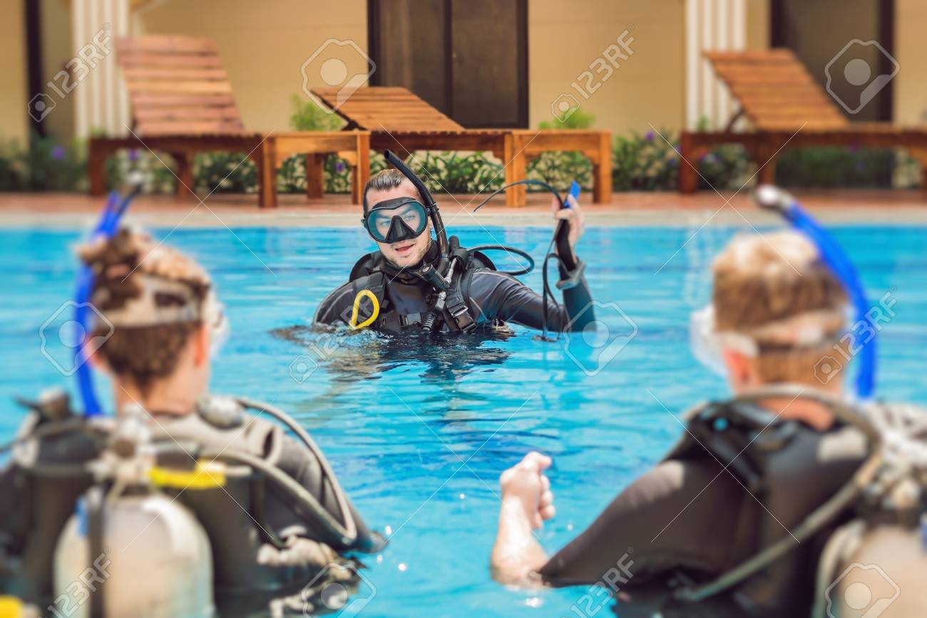 Diving instructor and students. Instructor teaches students to dive. - 93276783 Diving instructor and students. Instructor teaches students to dive. - 93276783