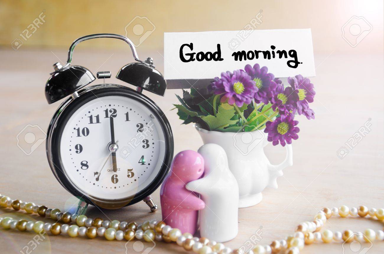 flowers in a ceramic pots with purple vintage alarm clock and