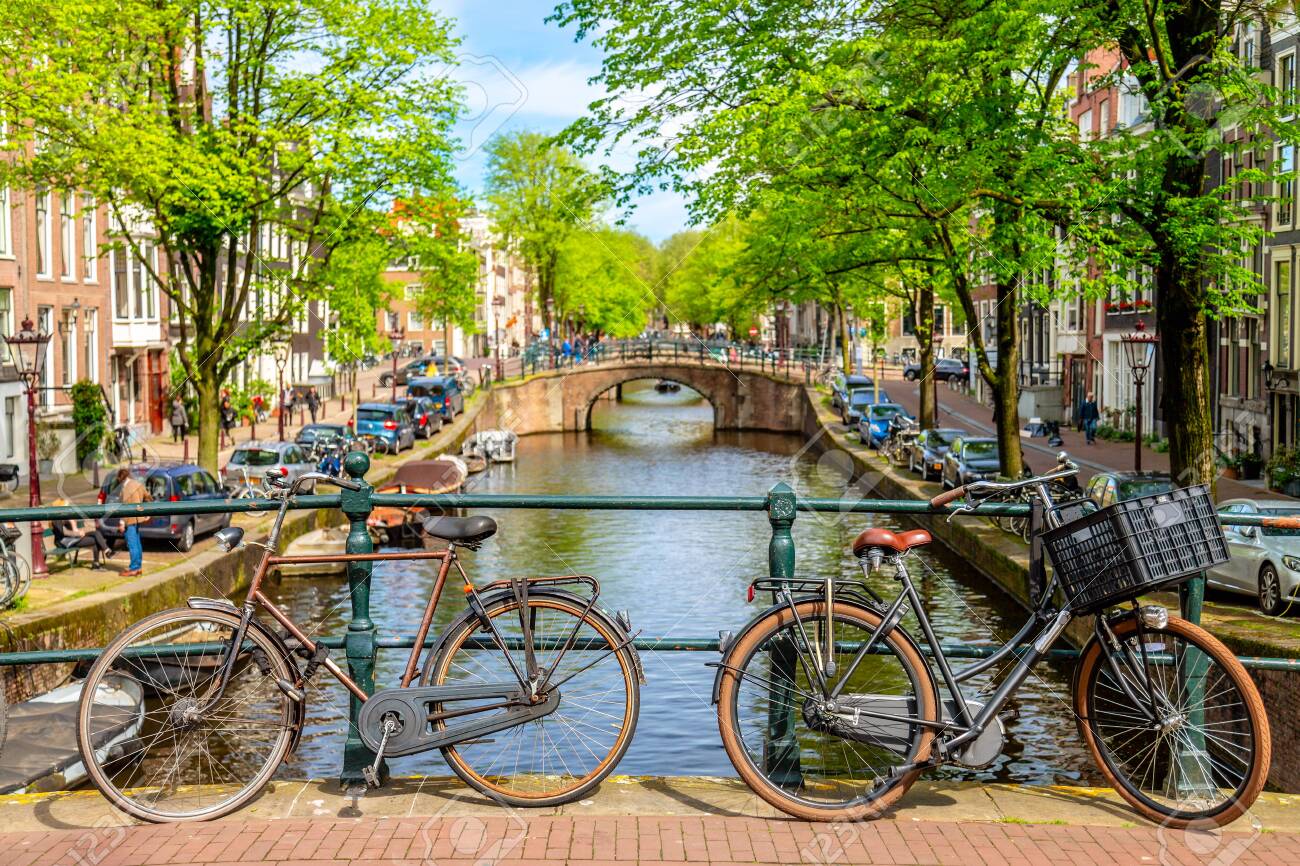 Old Bicycle On The Bridge In Amsterdam Netherlands Against A
