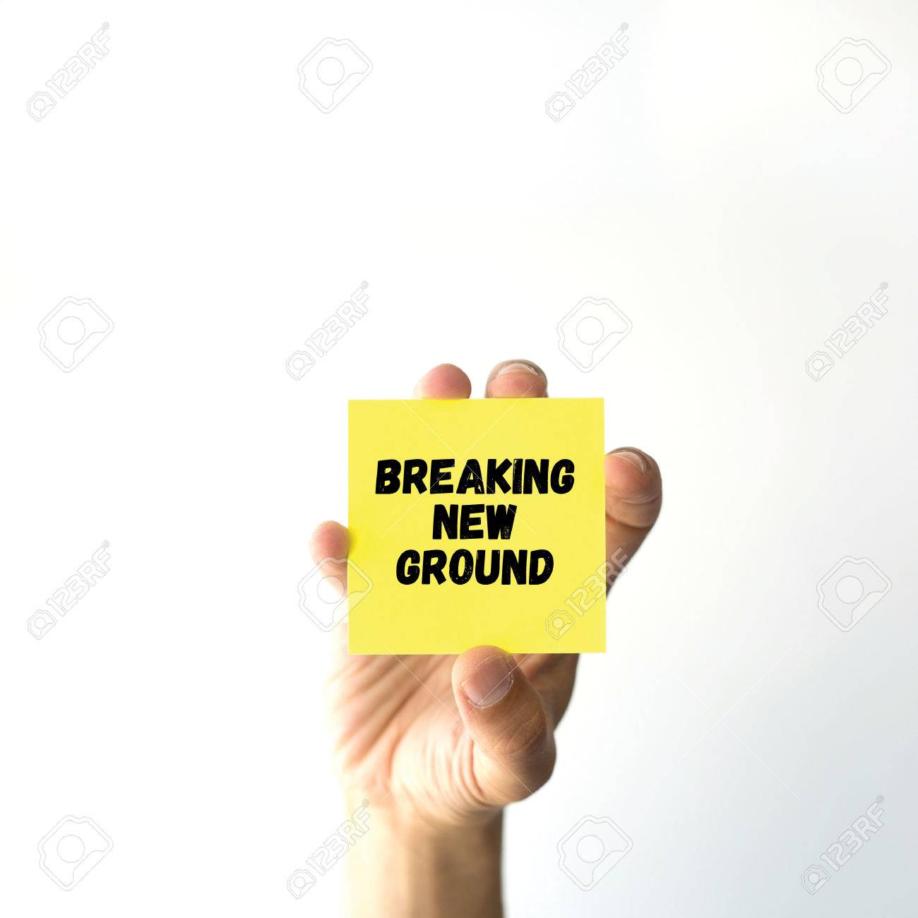 Hand Holding Yellow Sticky Note Written Breaking New Ground - 
