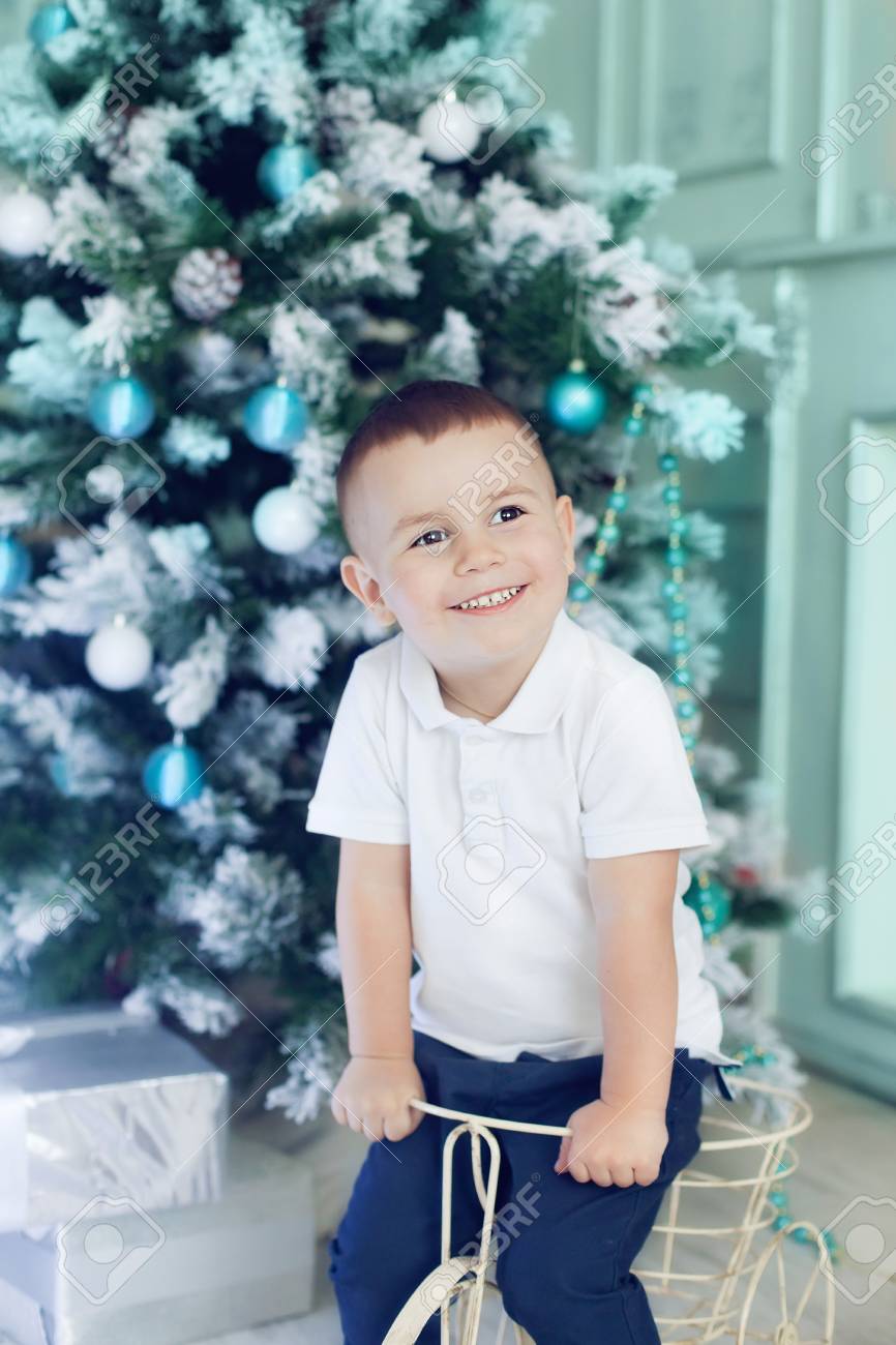 Fun boy 3 years old playing in the room decorated for the Christmas tree. Beautiful Christmas interior in white and blue colours, happy kid waiting for presents - 66916176 Fun boy 3 years old playing in the room decorated for the Christmas tree. Beautiful Christmas interior in white and blue colours, happy kid waiting for presents - 66916176