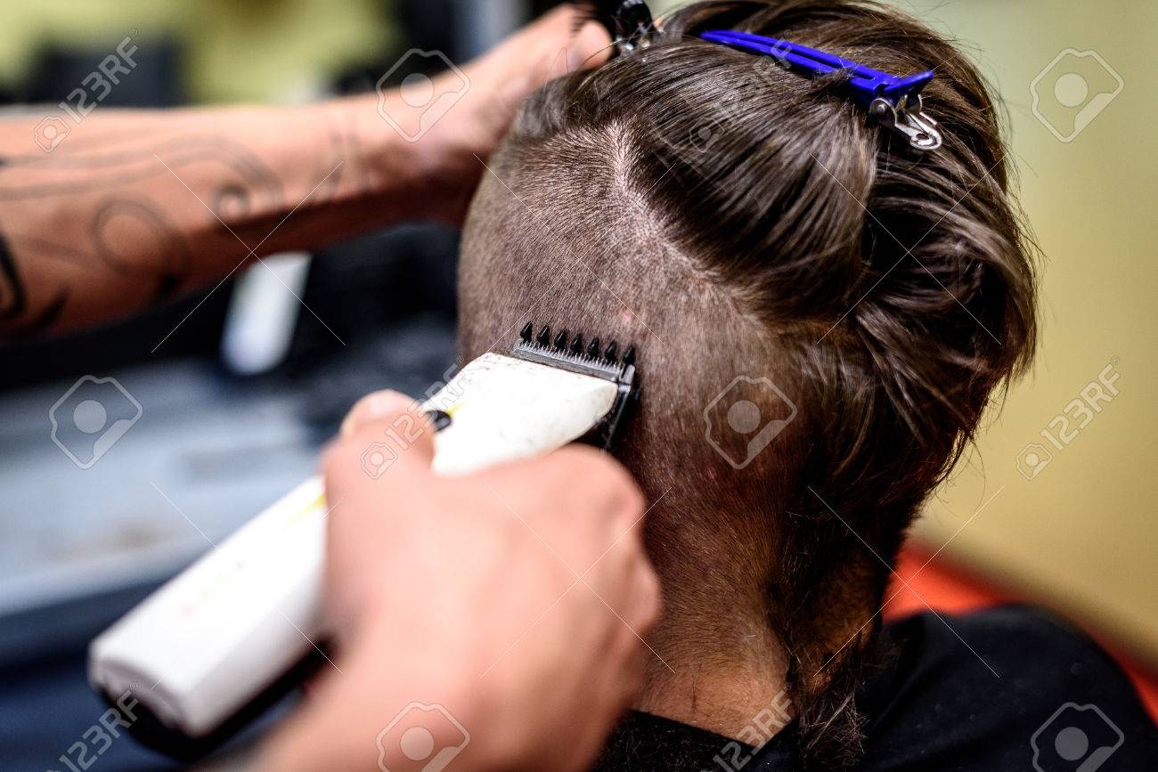 人が彼の髪のクローズ アップは トリマーで剃った 美容師の手は電動トリマーを保持 Costumers の頭を剃るします の写真素材 画像素材 Image