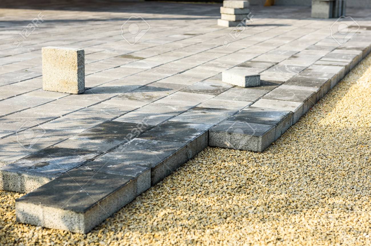 laying gray concrete paving