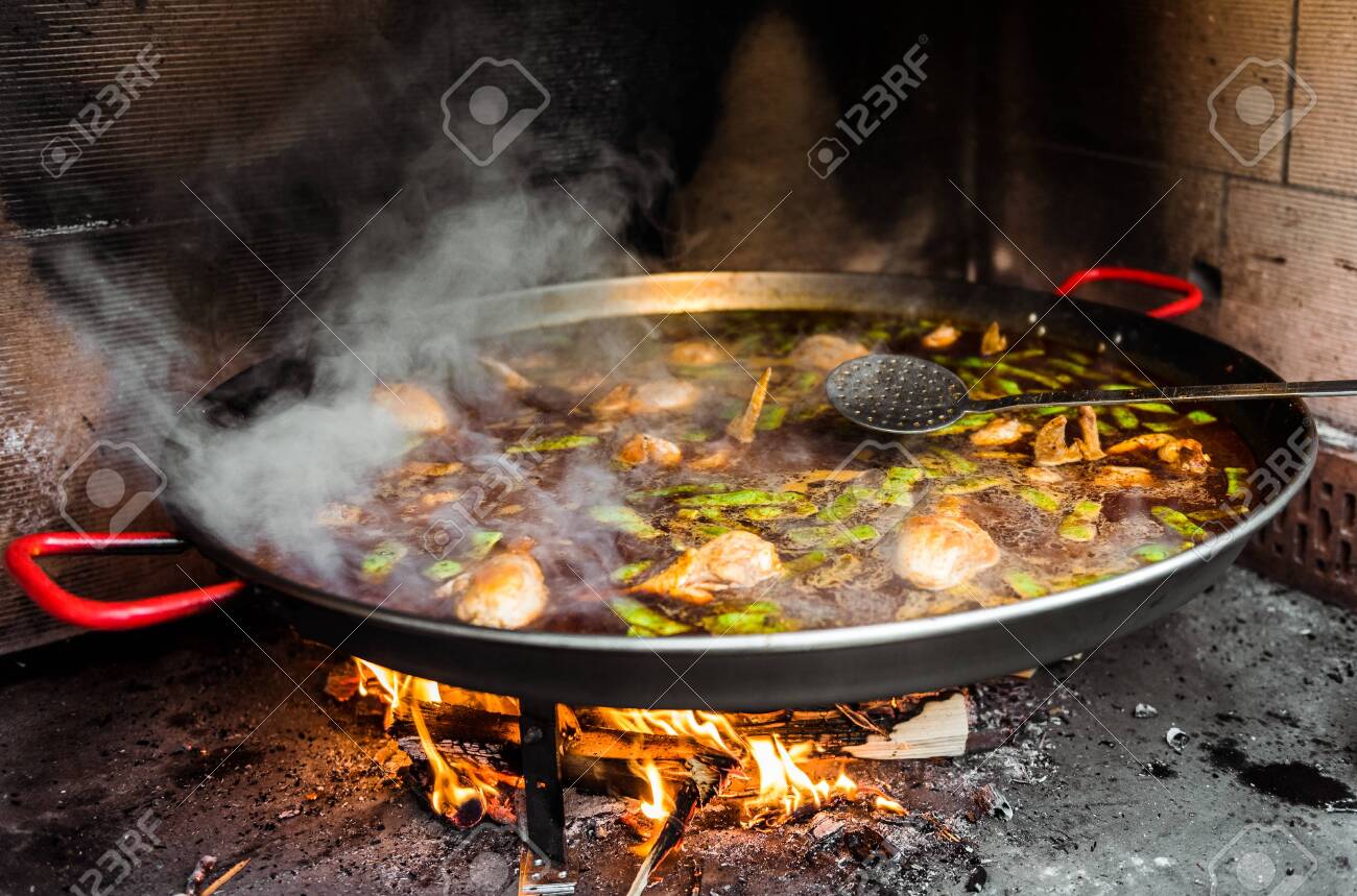 Cooking And Making A Traditional Spanish Paella Over Open Fire Traditional Way Of Preparing Valencian Paella
