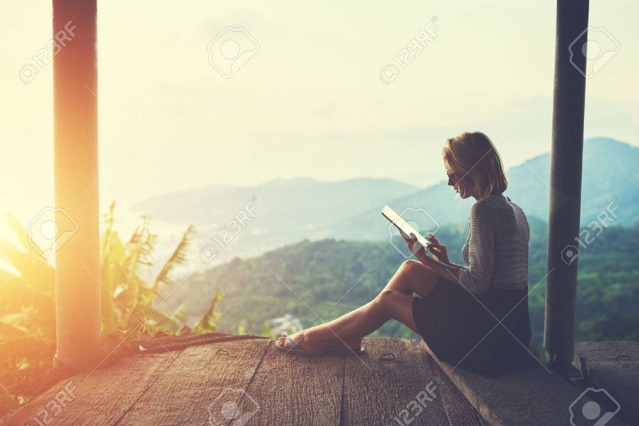 Female is typing something in diary on touch pad, while is sitting against amazing Asian landscape in beautiful summer evening. Woman is watching video on digital tablet during her trip in Thailand - 59076364 Female is typing something in diary on touch pad, while is sitting against amazing Asian landscape in beautiful summer evening. Woman is watching video on digital tablet during her trip in Thailand - 59076364