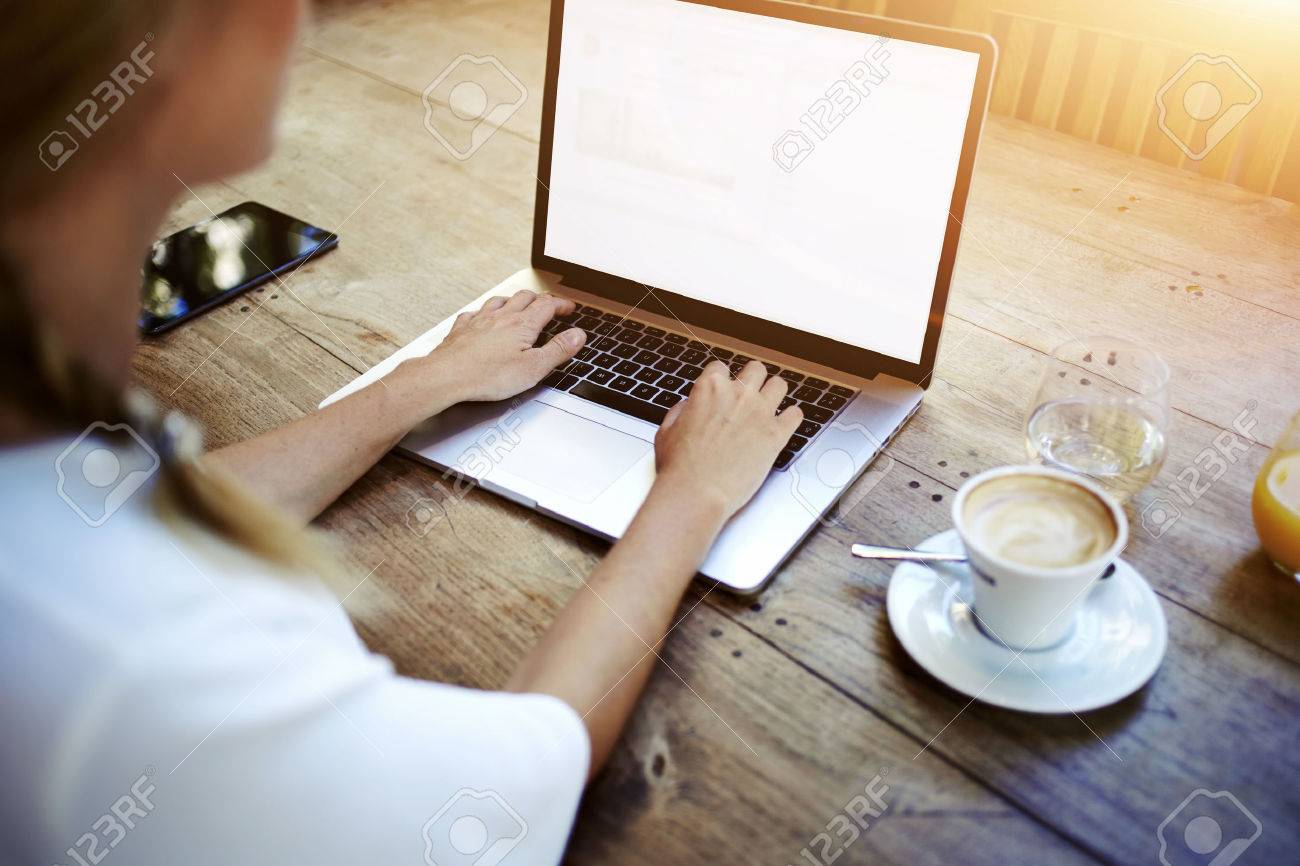 Cropped image of a woman's hands keyboarding on net-book while sitting at the wooden table in cafe, female student working on laptop computer with copy space screen background for your text message - 56368630 Cropped image of a woman's hands keyboarding on net-book while sitting at the wooden table in cafe, female student working on laptop computer with copy space screen background for your text message - 56368630