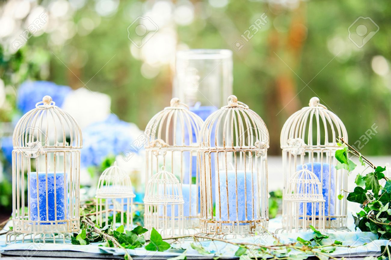 Blanc Décoration Millésime Cages à Oiseaux Avec Des Bougies Bleues Sur La Table De Mariage Avec Des Feuilles Vertes Sur La Nature De Fond
