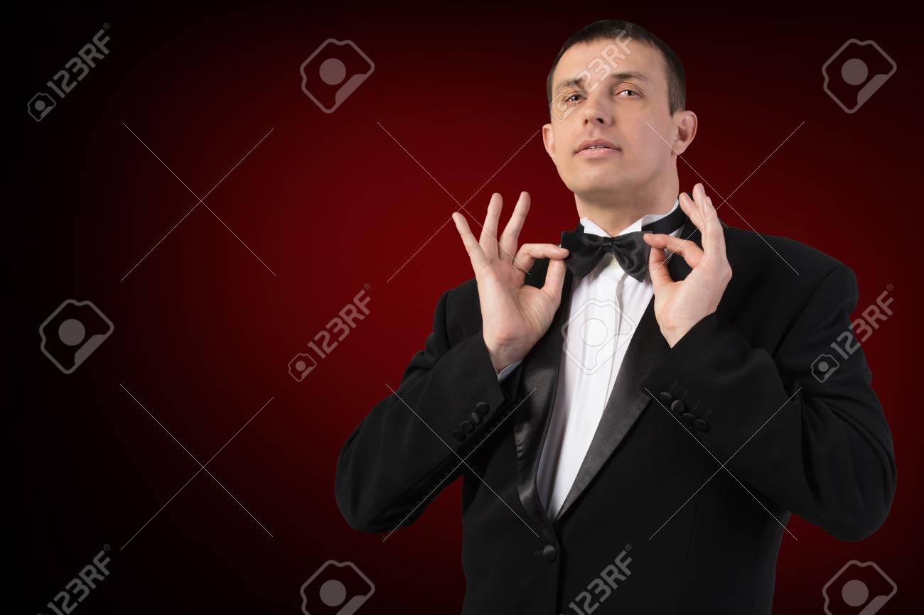 濃い赤の背景に黒のタキシードの男 の写真素材 画像素材 Image