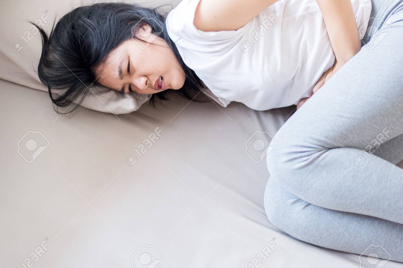 Asian Woman Having Painful Stomachache,Female Suffering From Abdominal Pain,Period  Cramps Stock Photo, Picture and Royalty Free Image. Image 94960027., image size:1300x865