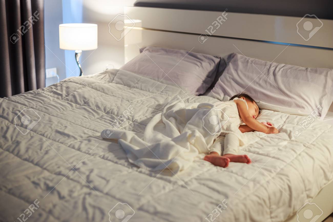 newborn sleeping in bed