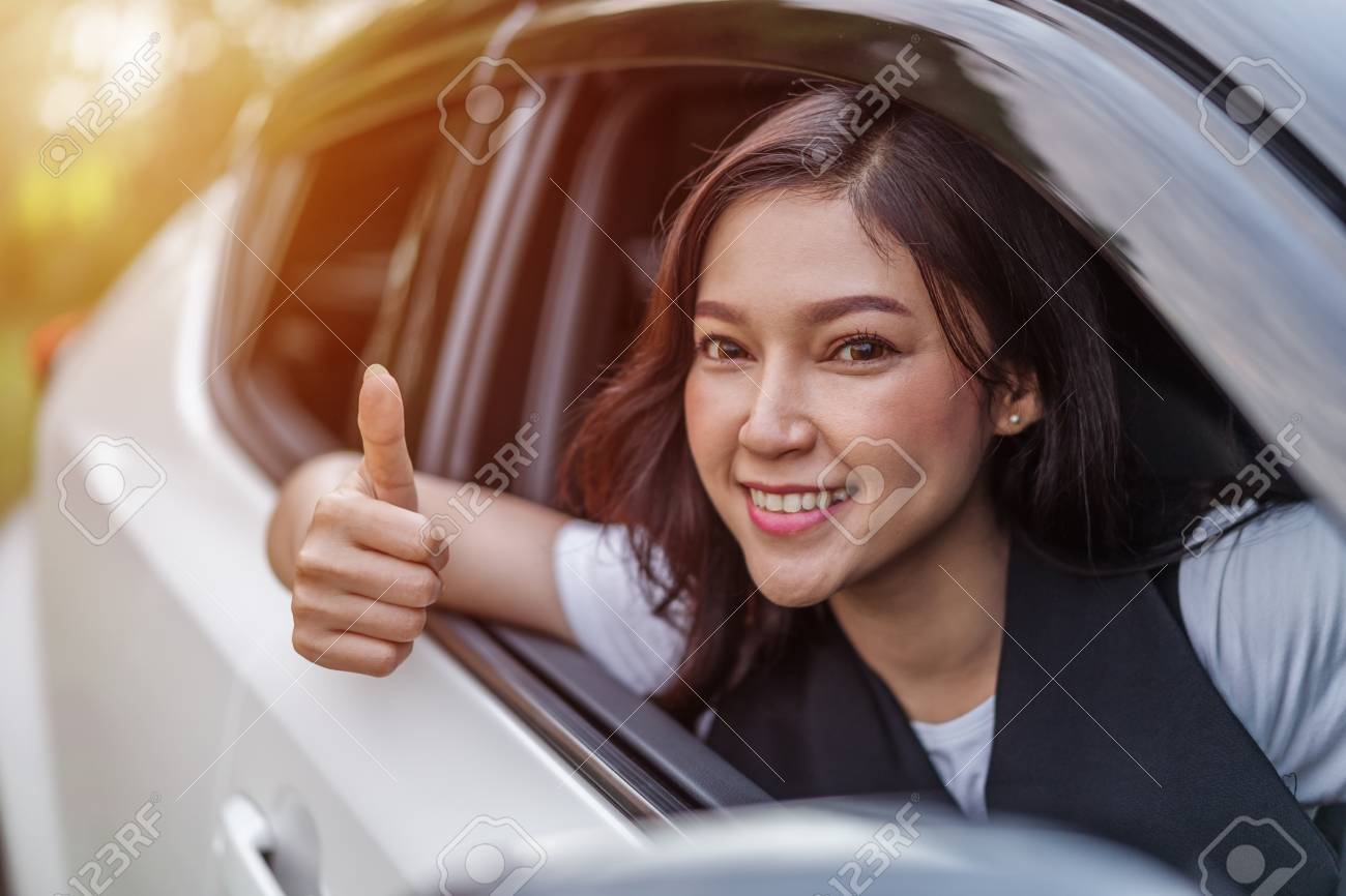 beautiful woman giving thumb up inside her car - 107619790 beautiful woman giving thumb up inside her car - 107619790