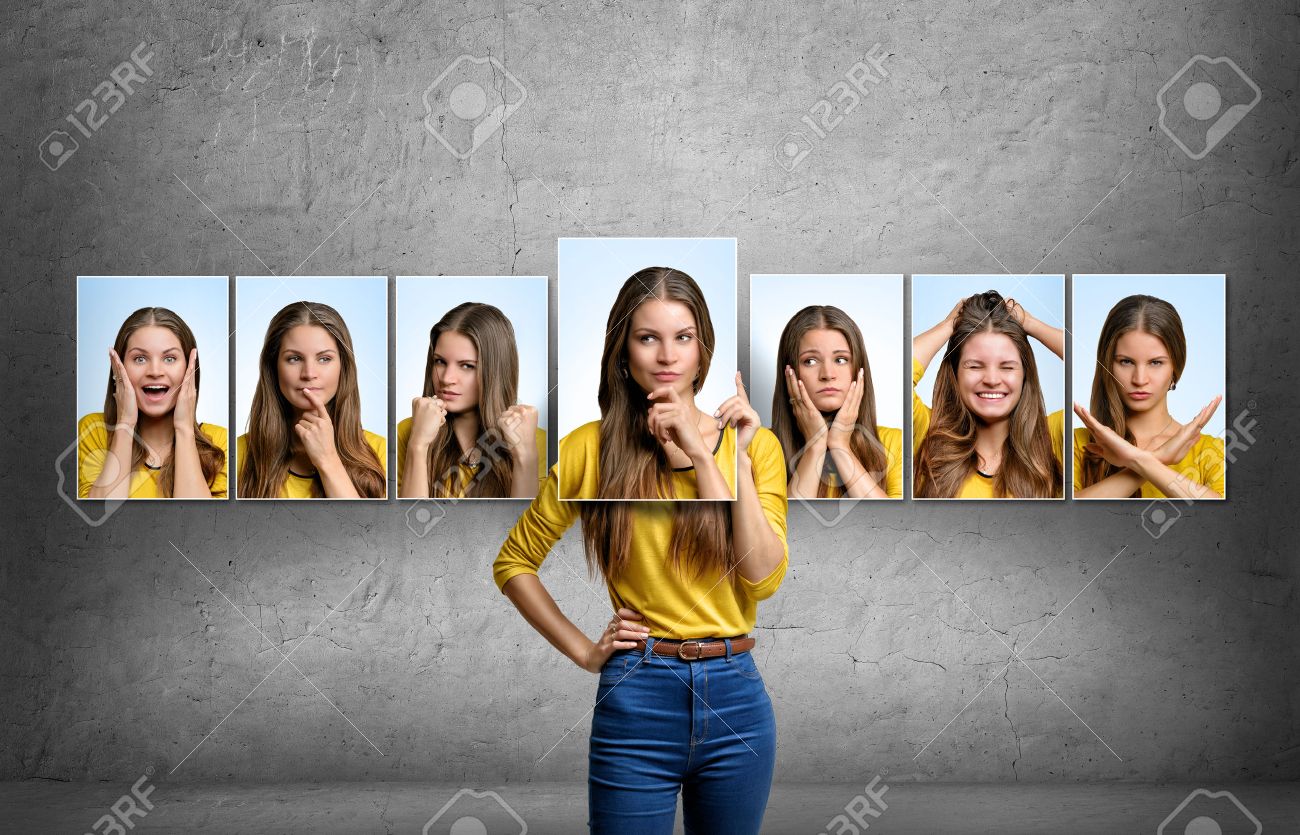 Young beautiful girl holds and changes her face portraits with different emotions. - 55737031 Young beautiful girl holds and changes her face portraits with different emotions. - 55737031