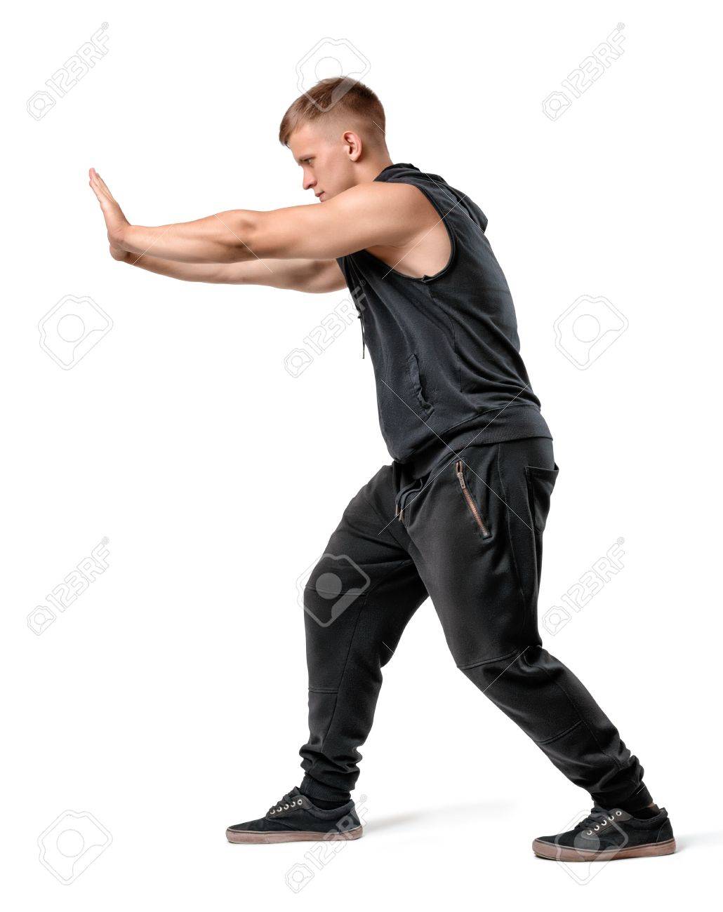 何か重いものが白い背景で隔離を押すハンサムな筋肉青年の側面図です の写真素材 画像素材 Image