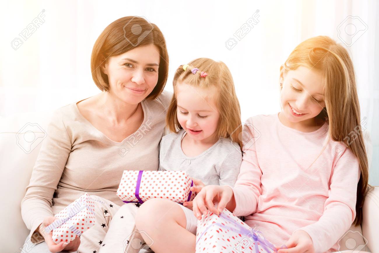 Cheerful Mom And Her Beautiful Daughters Exchanging Gifts Happy