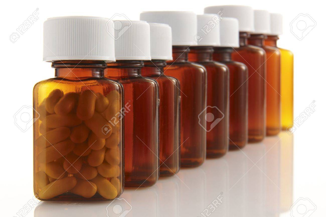 row of bottles with pills in the front container on white background - 7226013 row of bottles with pills in the front container on white background - 7226013