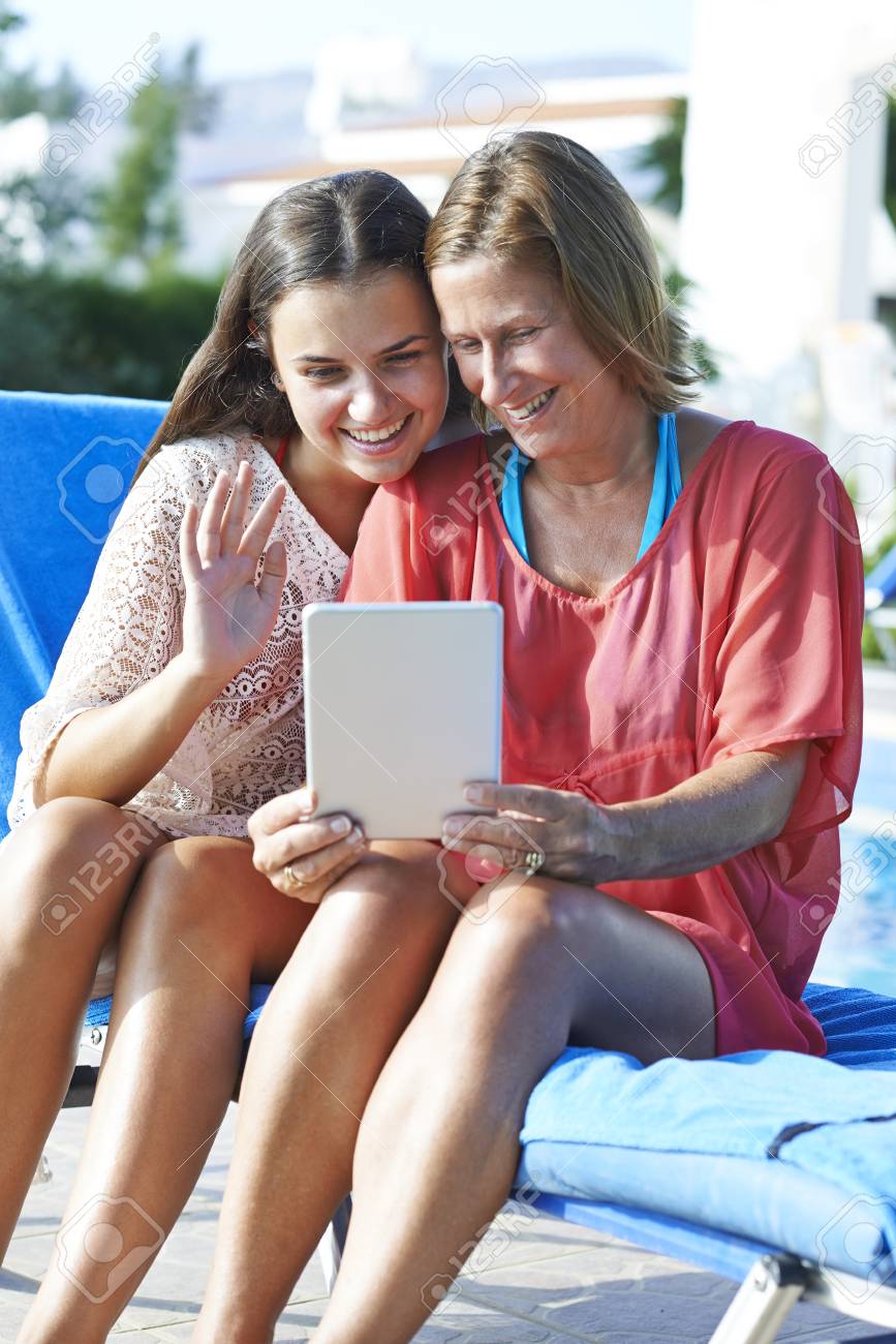 母と娘の友人や家族の休日の間デジタル タブレットを使用して連絡を取り合う の写真素材 画像素材 Image