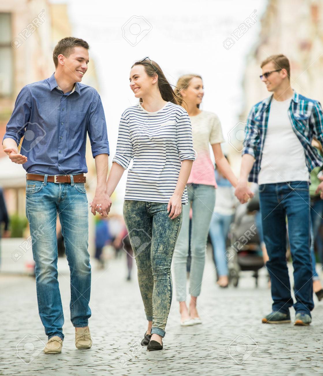 double couple date friends walking down the street together stock