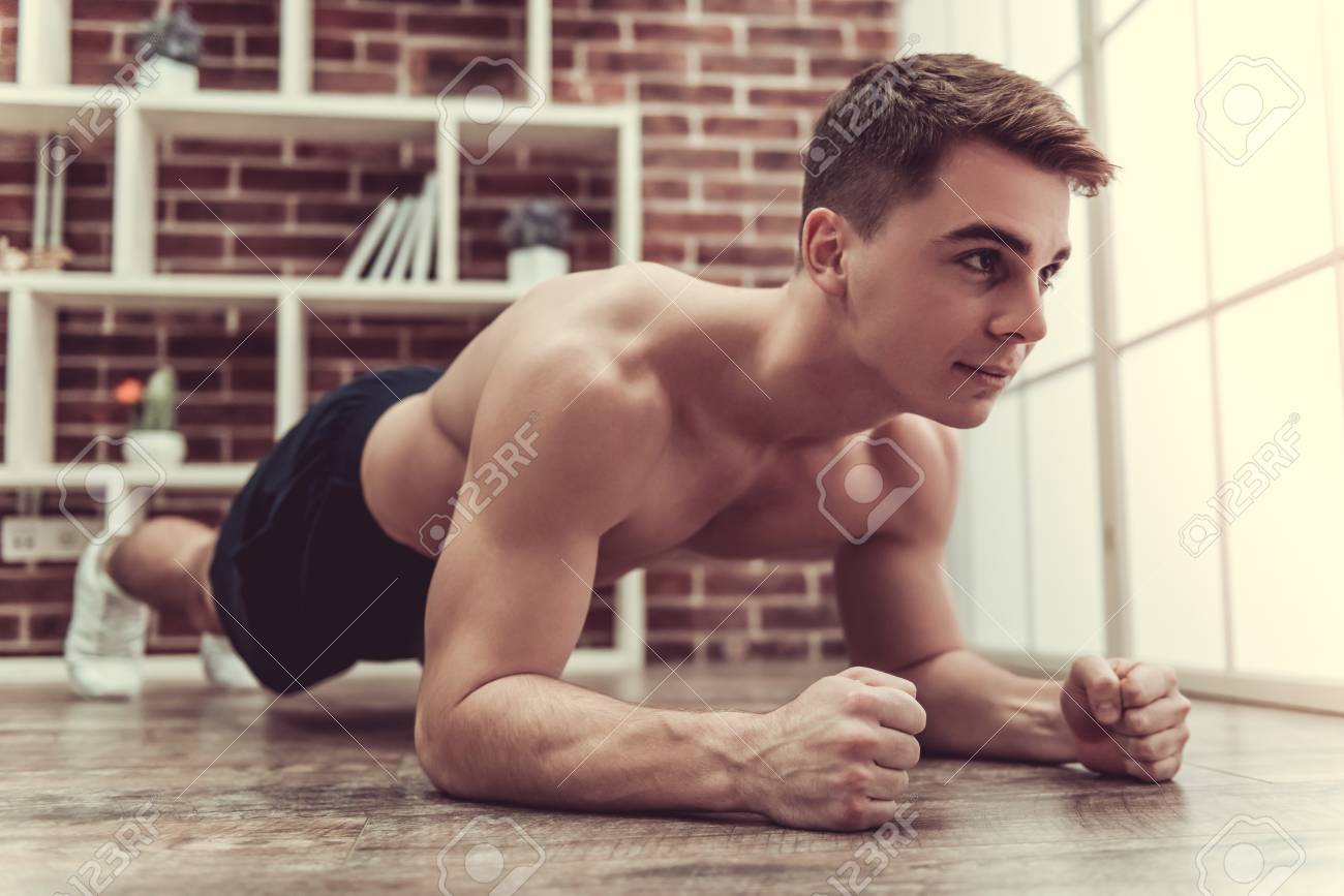 Chico Musculoso Guapo Con Torso Desnudo Está Haciendo Ejercicio De Tabla  Mientras Se Trabaja En Casa Fotos, retratos, imágenes y fotografía de  archivo libres de derecho. Image 77052041