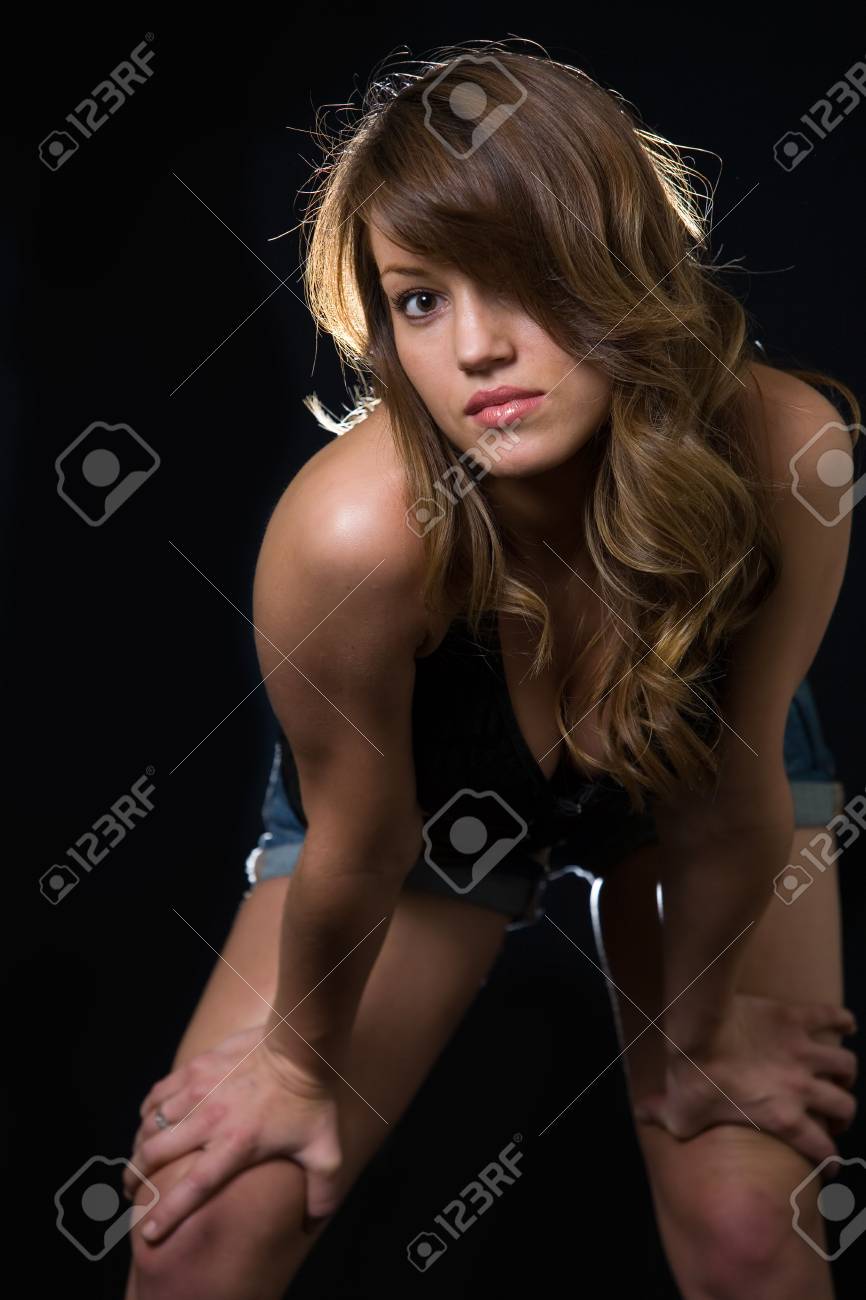 Attractive Long Hair Brunette Caucasian Woman Leaning Forward While Standing Over Black Background Stock Photo, Picture and Royalty Free Image picture