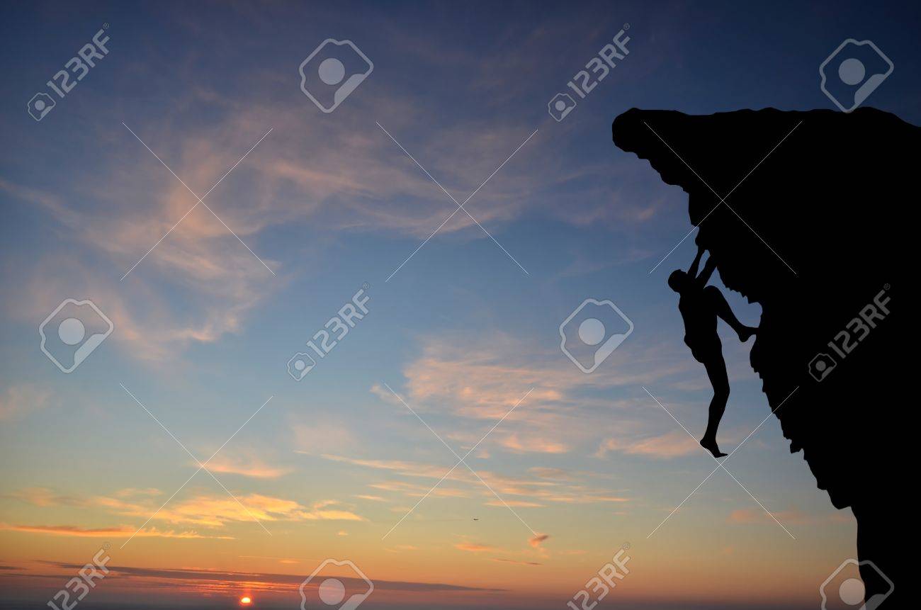 silhouette of a person without insurance climbs the rock in the background of the sunset - 12296307 silhouette of a person without insurance climbs the rock in the background of the sunset - 12296307