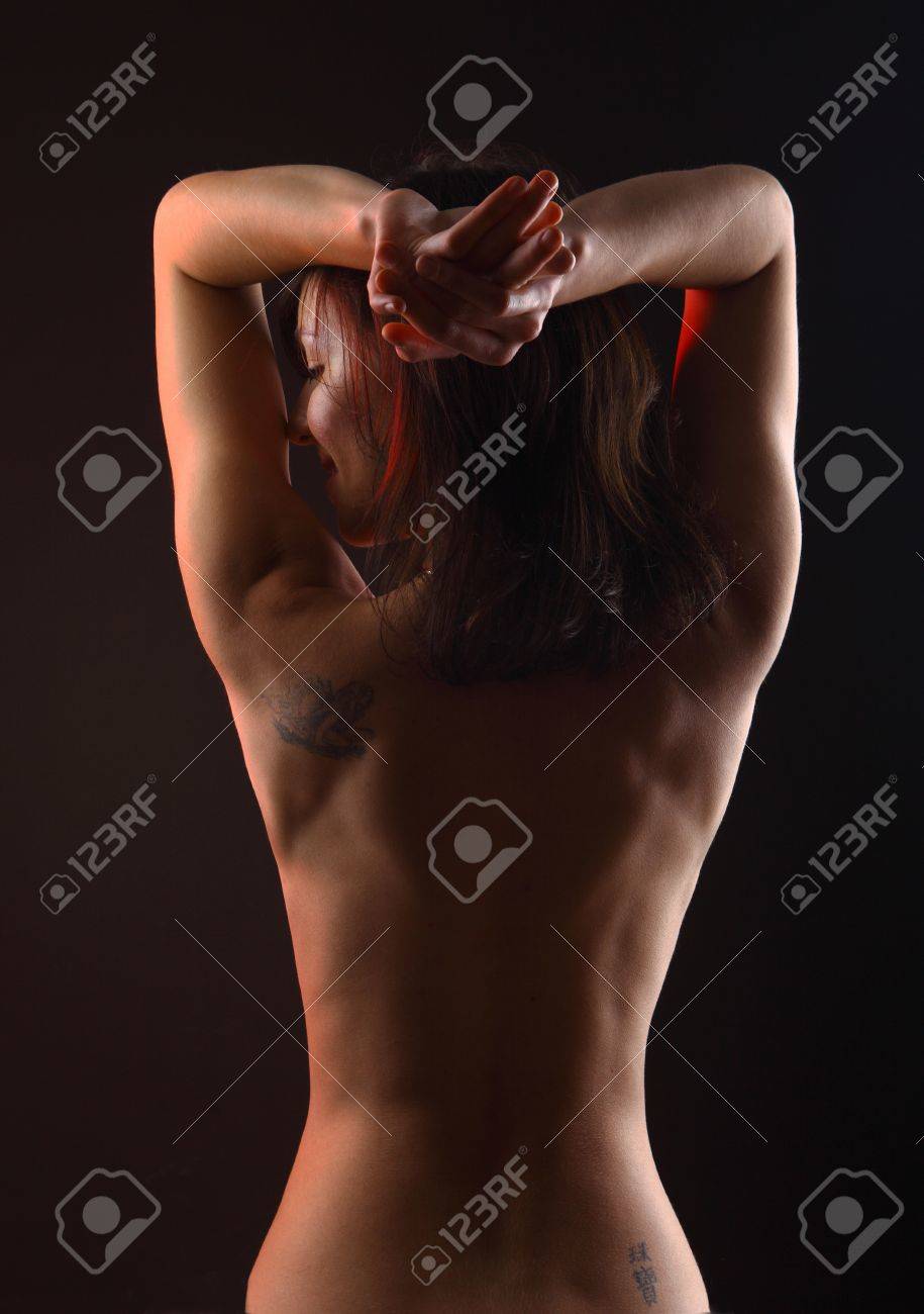 Eine Schone Junge Frau Von Der Hufte Abwarts Suchen Um Ihre Linke Mit Ihren Armen Nackt Oben Angesprochenen Und Ein Tattoo Hoch Uber Ihrer Rechten Pobacke Lizenzfreie Fotos Bilder Und Stock Fotografie