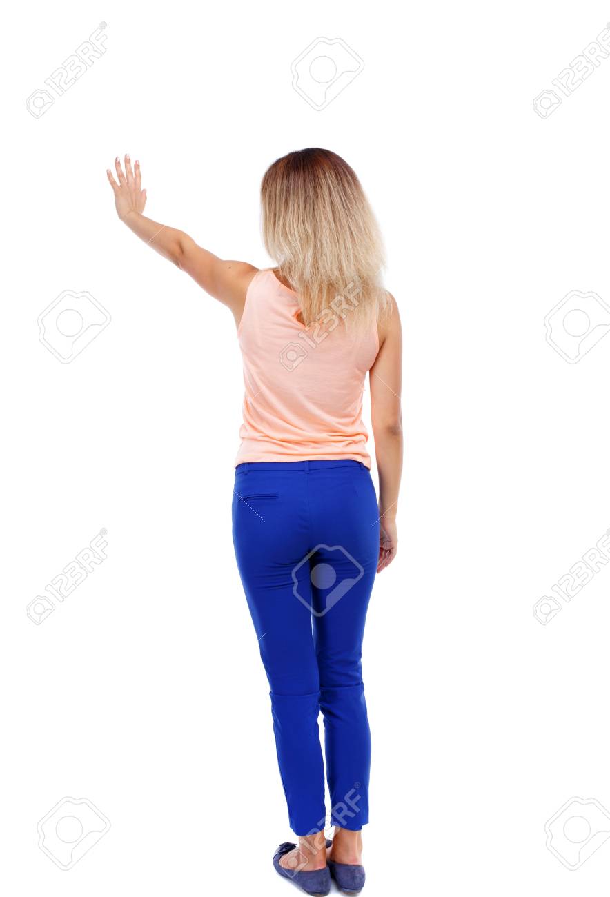 美しい女性歓迎を背面します ジーンズからは手を振り 若いティーンエイ ジャーの女の子 白い背景に分離されました 金髪の青いズボンは 彼の手をボタンを押します の写真素材 画像素材 Image