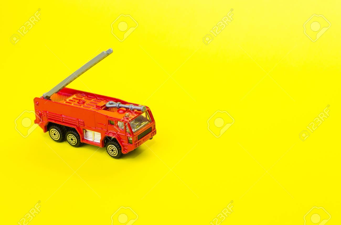 Miniature Red Color Fire Truck On Yellow Background Toy Car