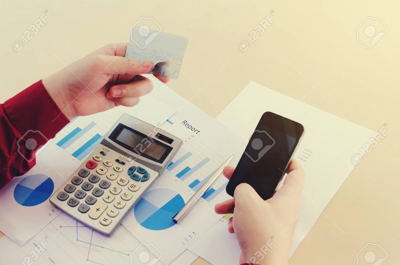 top view of hand using mobile smart phone and holding credit stock online credit card calculator