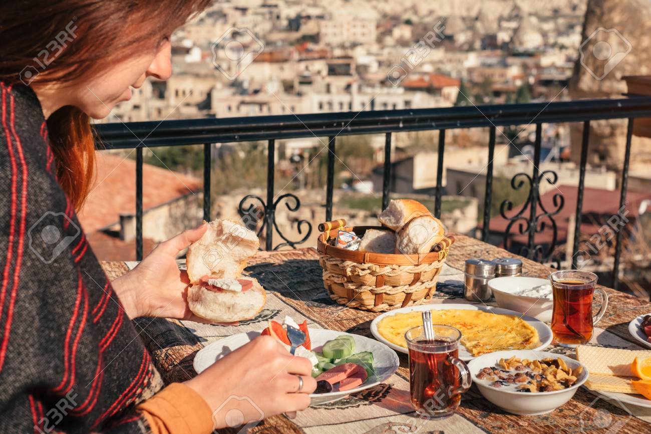 観光客女性背景カッパドキアのギョレメ市で伝統的なトルコ式の朝食を食べる の写真素材 画像素材 Image