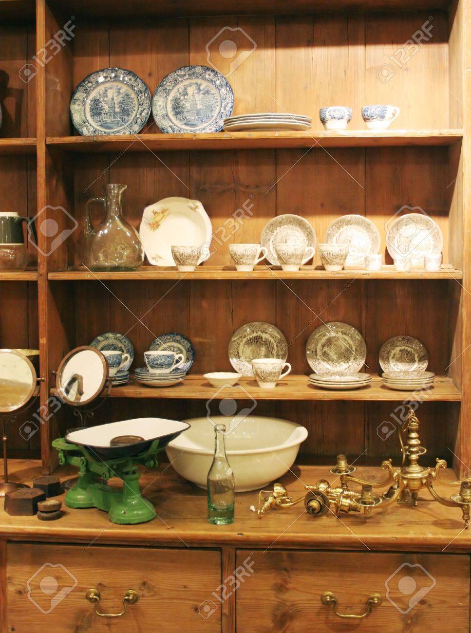 Wooden Cabinet Displaying Antique Objects Including Plates And
