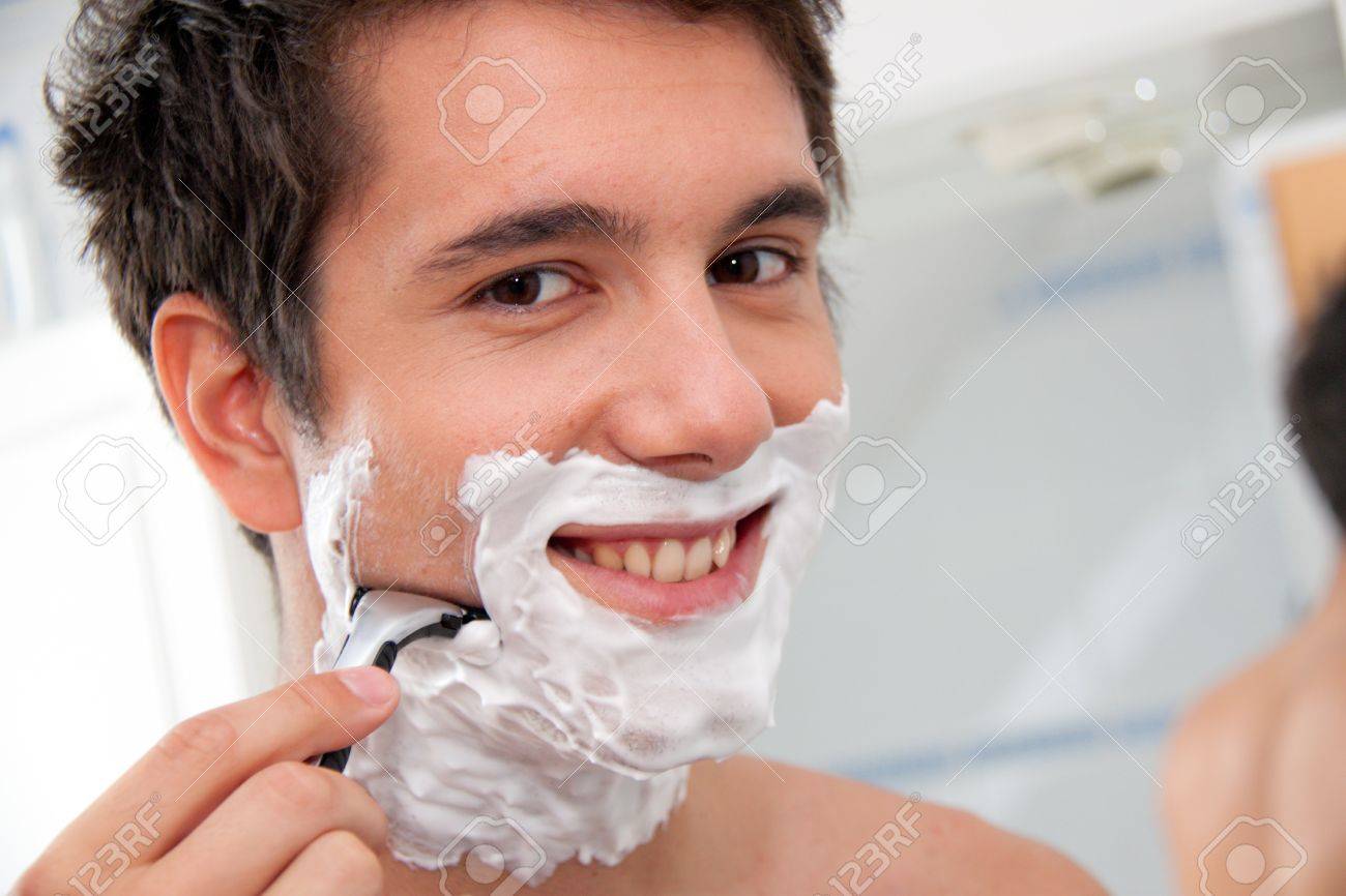 joven rasurado con razor y crema de afeitar en cuarto de baño fotos rasurado