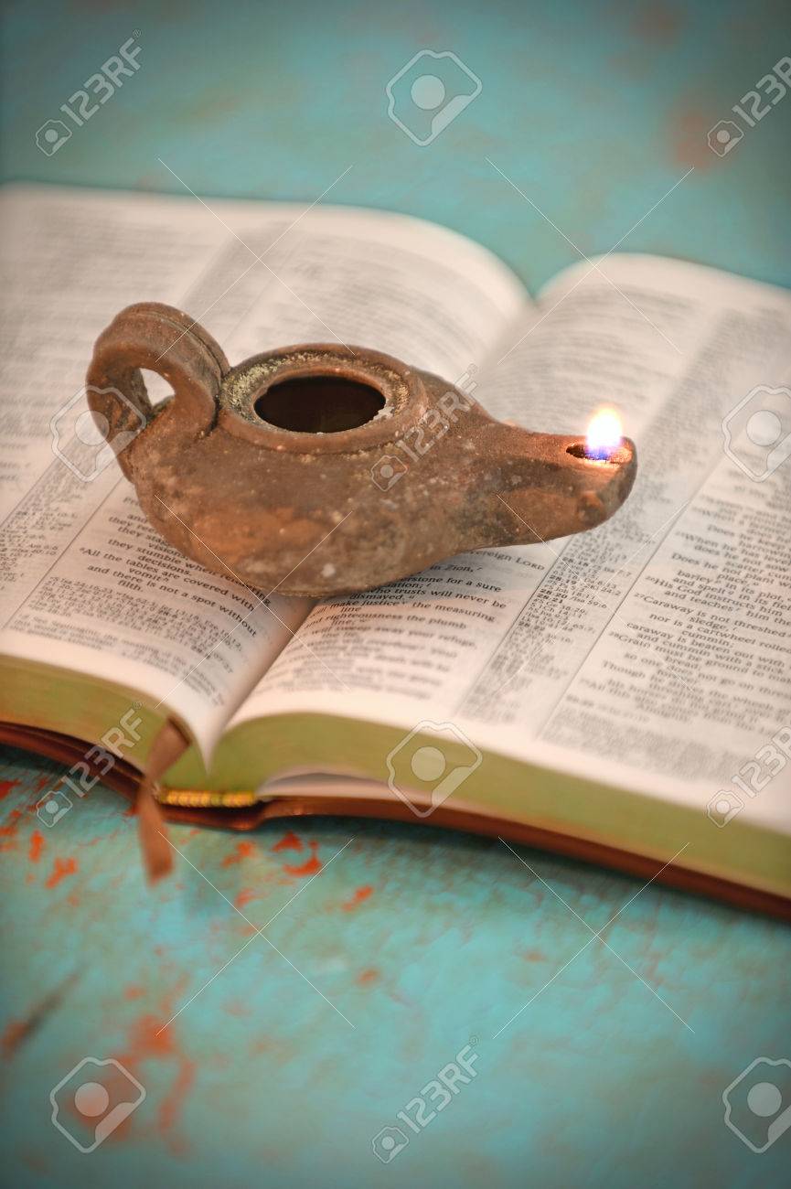 Vintage oil lamp over open Bible on old table - 47647280 Vintage oil lamp over open Bible on old table - 47647280