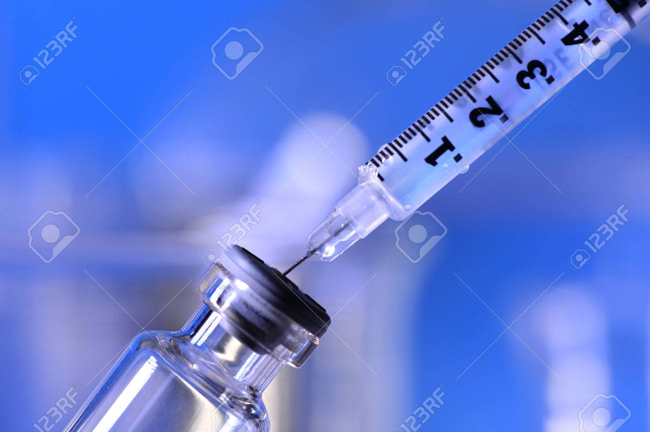 Syringe being inserted into a vial in a laboratory - 63779193 Syringe being inserted into a vial in a laboratory - 63779193