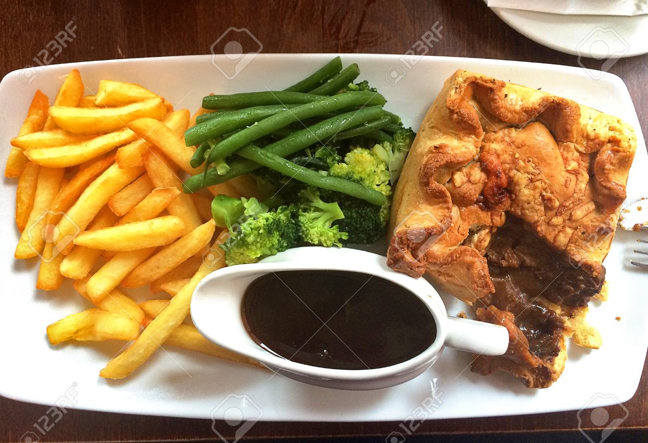 british lunch steak pie with chips broccoli and gravy stock photo