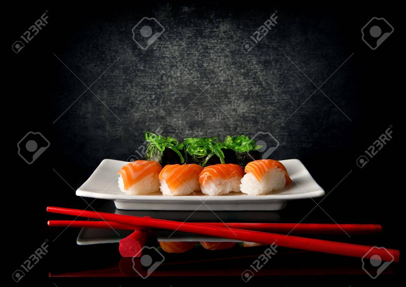 Sushi on plate with red chopsticks on black background - 50561058 Sushi on plate with red chopsticks on black background - 50561058