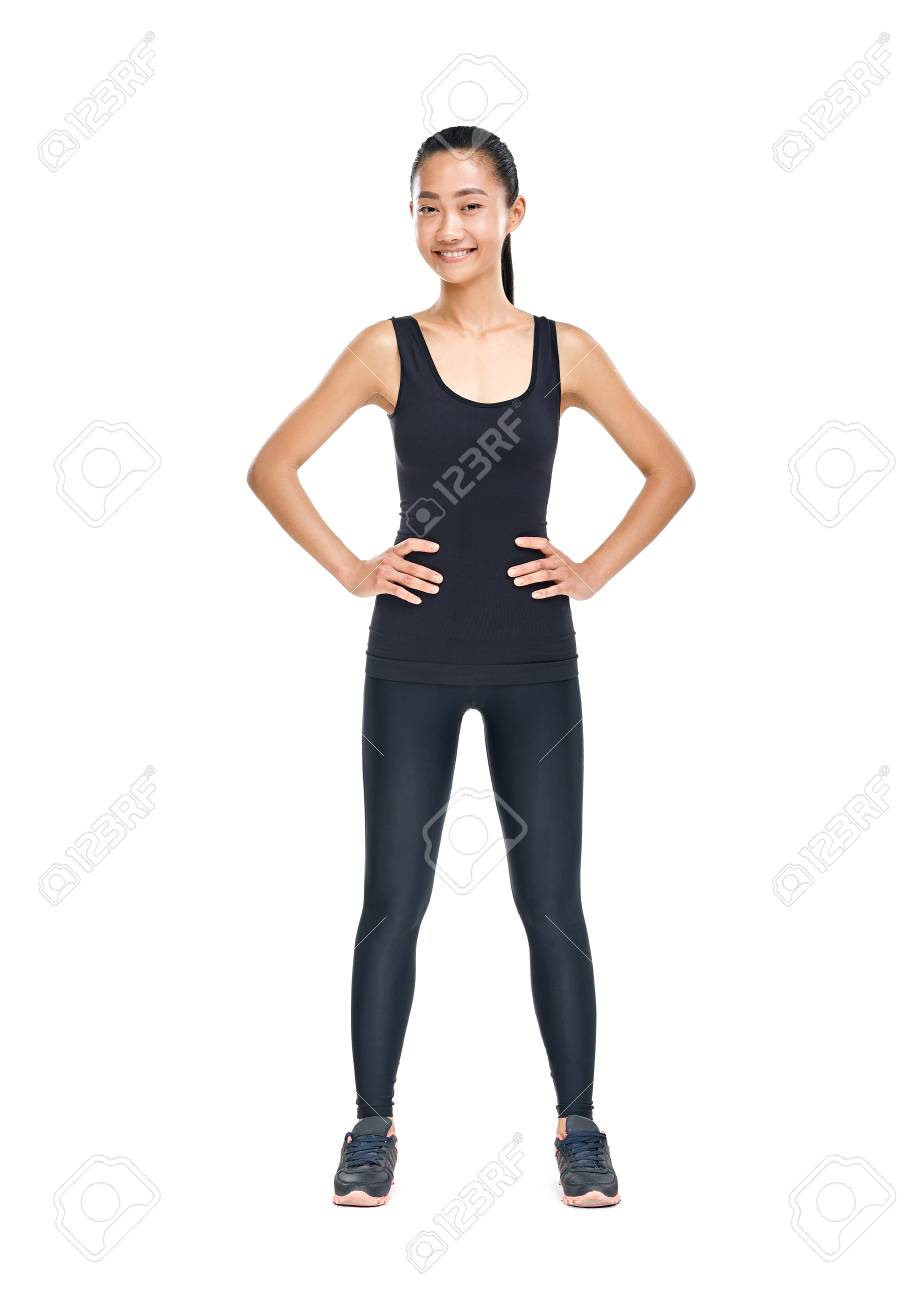 スポーティなスタイル立っている腰に手を置くことで 若い細いアジア女性 黒トレーニング服の女性の運動選手の完全な長さの肖像画を分離 カメラ目線で幸せな笑顔をモデルします の写真素材 画像素材 Image