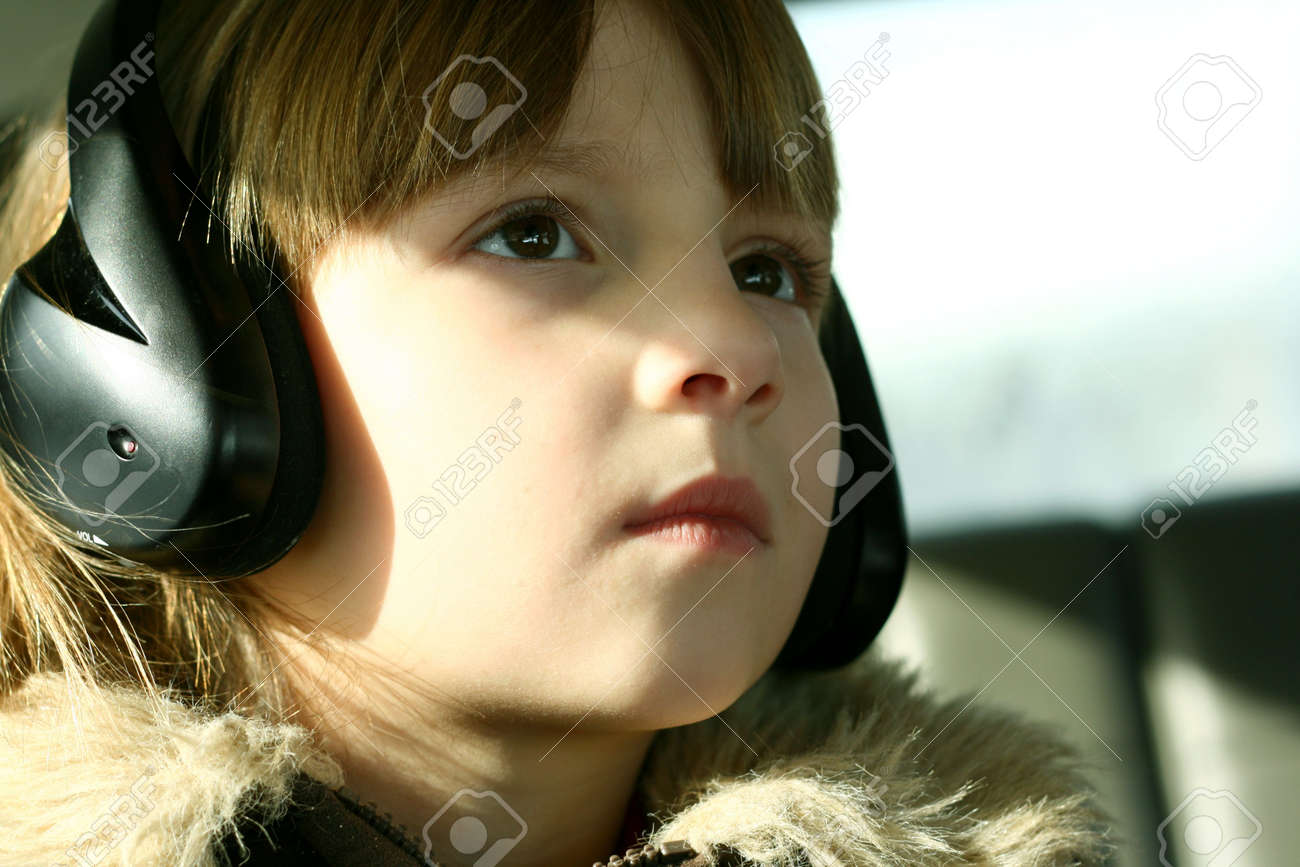 小さな女の子が着てヘッドフォンや Dvd を見ている車 の写真素材 画像素材 Image