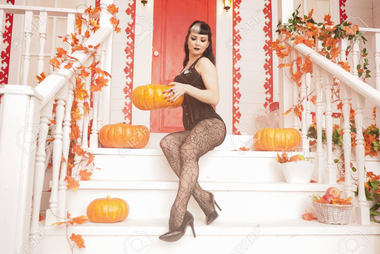 Heiße Frau Kommt Für Süßes Oder Saures Halloween-Nacht. Gotisches  Vampirmädchen Auf Der Weißen Veranda Des Verzierten Herbsthauses  Lizenzfreie Fotos, Bilder und Stock Fotografie. Image 131713792.