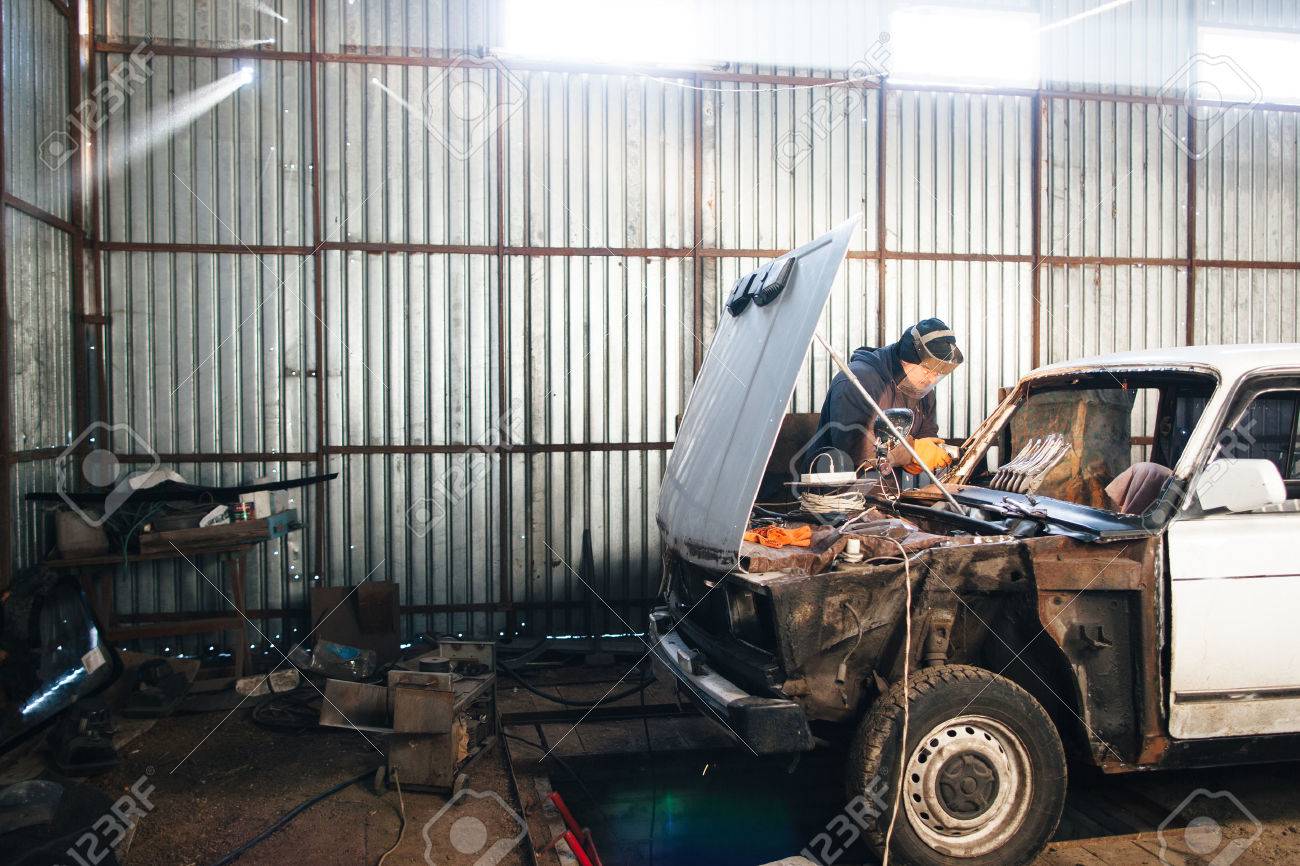 Service station for old damaged automobile. Bodywork and restore body and engine compartment. Workshop background - 52489760 Service station for old damaged automobile. Bodywork and restore body and engine compartment. Workshop background - 52489760